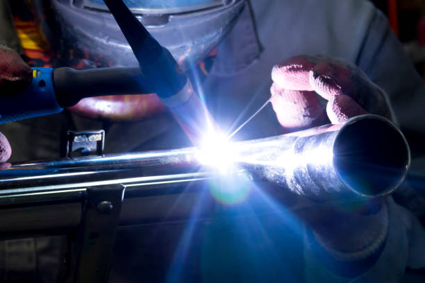 TIG welding of polished stainless steel pipe TIG welder welds elbow to polished stainless steel pipe titanium stock pictures, royalty-free photos & images