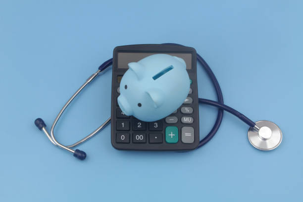 istock Piggy bank, calculator and stethoscope blue background. 1372918612