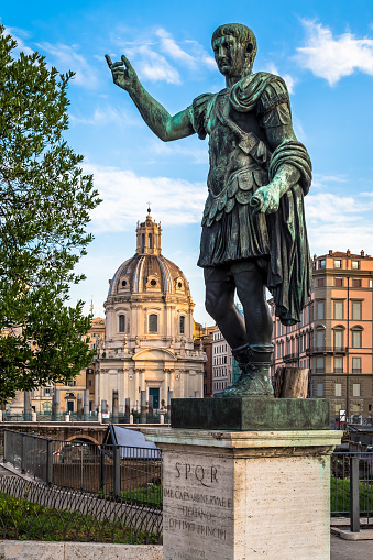ITALY, ROME - CIRCA AUGUST 2020: Statue of Caesar Emperor, made of bronze. Natural sunrise light. Ancient  role model of Leadeship and Authority .