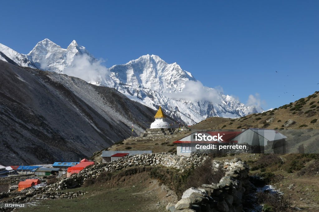 Stupa in the Sherpa village Dingboche and snow covered mountain Thamserku. Architecture Stock Photo