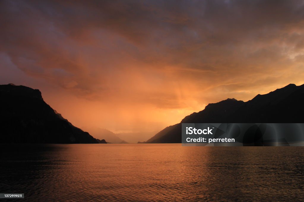 Moody sky over Lake Brienz, Switzerland. Thunderstorm arriving in the Bernese Oberland. Dramatic sky over Lake Brienz and outlines of Mount Augstmatthorn. Dusk Stock Photo