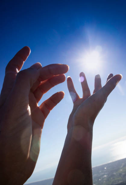 istock Female hands in the blue sky in the backlight 1372924569