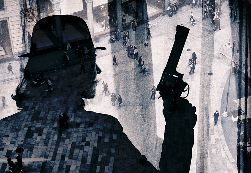 Shot of unrecognizable person with gun superimposed over a cityscape. The city is Milan, Italy.