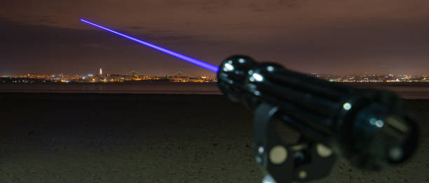Blue beam laser device for activities with projection to the sky at dark night, Lisbon city background stock photo
