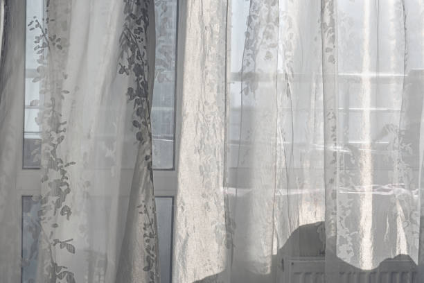 istock Thin white transparent curtain hanging on window at early morning 1372930506