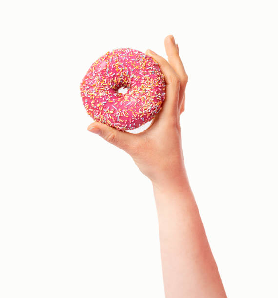 hand zeigt einen rosa donut - strawberry fruit single object food stock-fotos und bilder