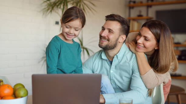 istock Happy family using laptop and making video call at home 1372944944