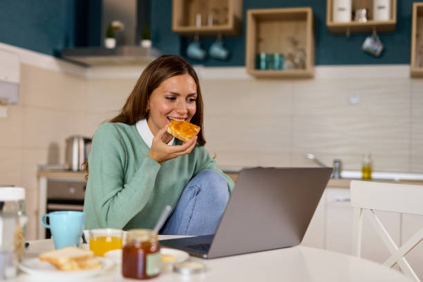 istock Young woman making a video call on her laptop during breakfast 1372944960
