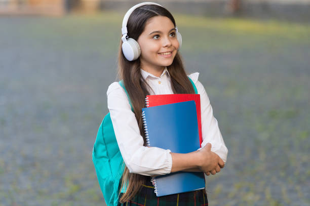 Music is universal language of mankind. Happy child listen to music outdoors. Little kid wear headphones playing music. Music school. New technology. Modern life. Education and learning. Ear training. la música es el lenguaje universal de la humanidad. niño feliz escucha música al aire libre. el niño pequeño usa auriculares para reproducir música. escuela de música. nueva tecnología. vida moderna. educación y aprendizaje. entrenamiento del oíd