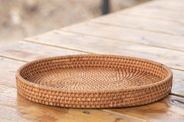 round rattan basket isolated on wooden background. stock photo