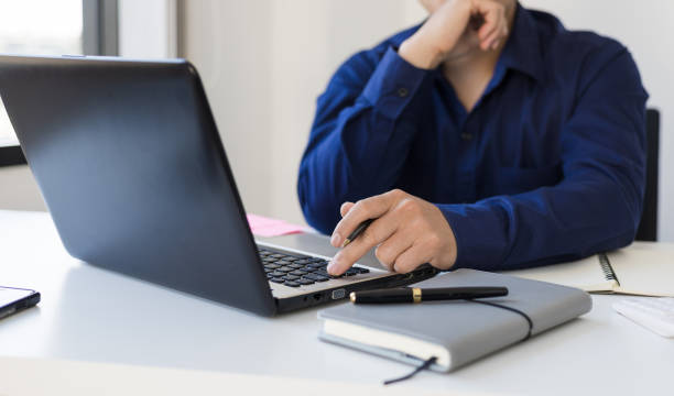 istock Businessman contemplating while working on laptop in office. 1372959852