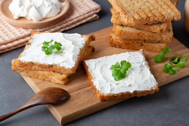 istock Bread with cream cheese on grey table. Whole grain  bread with seeds 1372960666