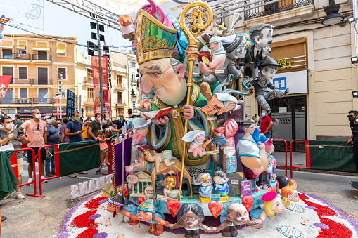 General view of a Falla during Las Fallas Festival on September 3, 2021 in Valencia, Spain. The Fallas is Valencias most international festival, which runs from March 15 until March 19, but because the COVID, in 2021 was celebrated in september. It celebrates the arrival of spring with fireworks, fiestas and bonfires made by large puppets named Ninots. During the months preceding this unique festivity, a lot of hard work and dedication is put into preparing the monumental and ephemeral cardboard statues that will be devoured by the flames. The festival has been designated as a UNESCO Intangible Cultural Heritage of Humanity since 2017. People visit and look the falla.
