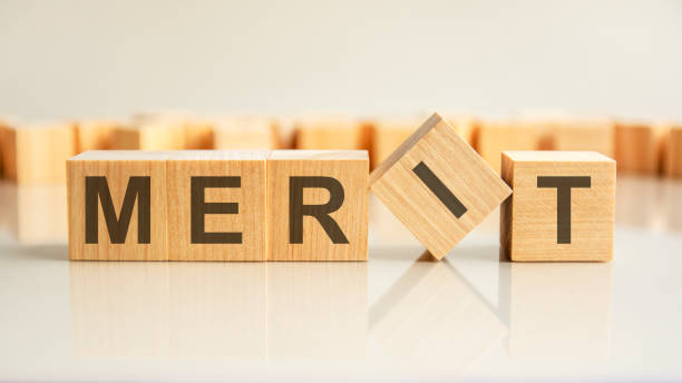 istock merit text on a wooden blocks, gray background. 1372962608