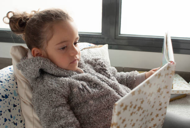 istock LITTLE GIRL READING A STORY 1372964515