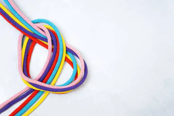 Heart shaped made of five multicolored cords twisted on a concrete background. Creative relationship concept.