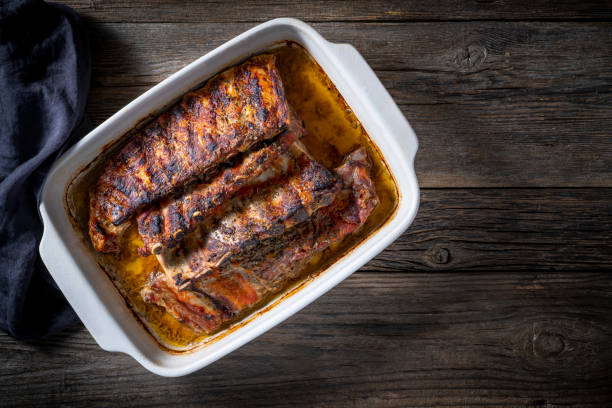 Roasted ribs in a tray with herbs and spices