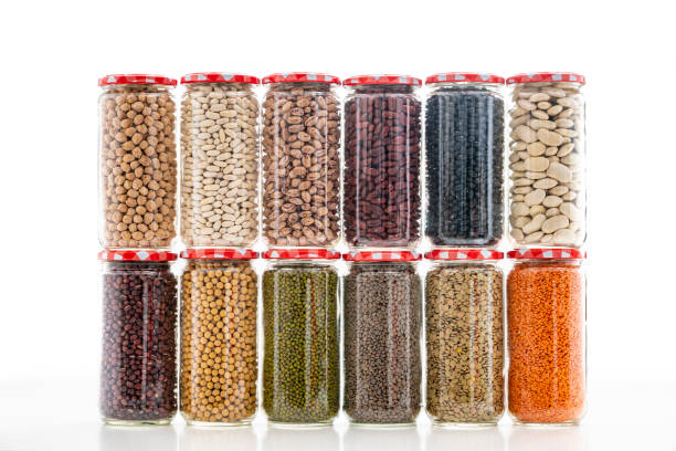 istock Assorted legumes in glass jar in a row on white background 1372970114