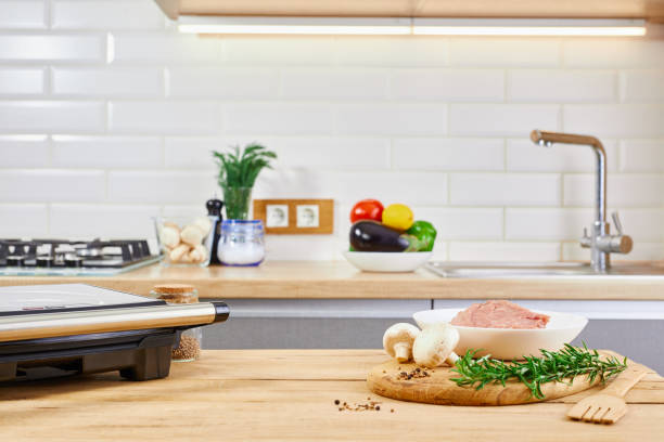 istock Barbecue preparing in the kitchen interior. Electric grill barbecue and meat on kitchen table. 1372970720