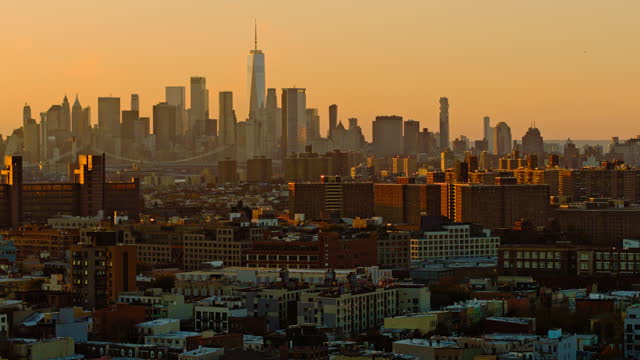 Remote view of Downtown Manhattan and Freedom Tower in the evening before sunset. Distant view from Brooklyn's residential area. Birds are flying. Aerial video with the panning camera motion.