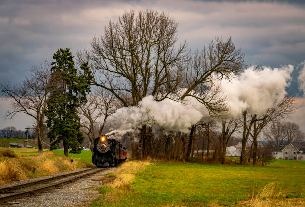 istock View of an Antique Freight Steam Train Blowing Smoke Approaching Thru Trees 1372980331