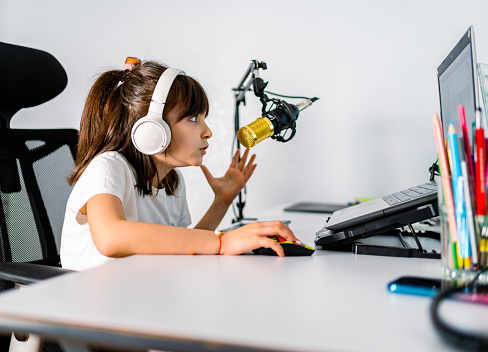 Image of young blogger girl recording broadcast with microphone