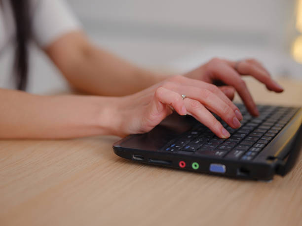 istock smiling young woman looking at laptop screen at kitchen 1372983053