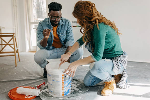 istock Young  couple painting walls 1372984255