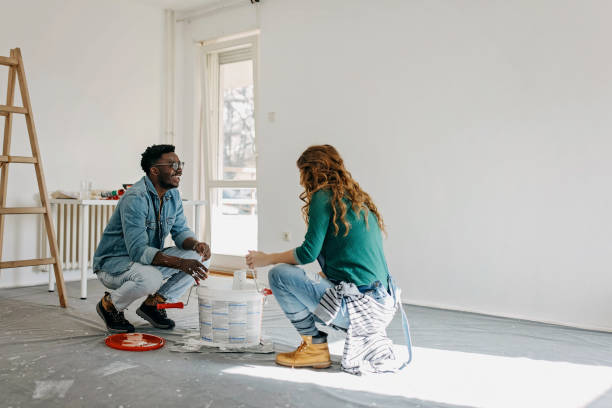 istock Young  couple painting walls 1372984284