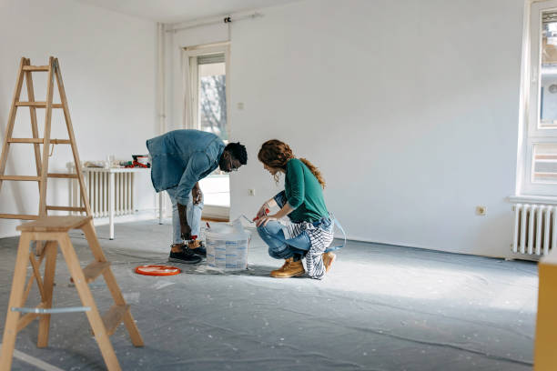 istock Young  couple painting walls 1372984867