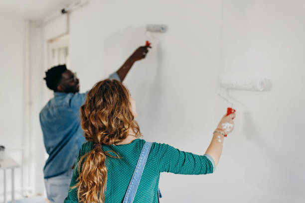 istock Young  couple painting walls 1372984870