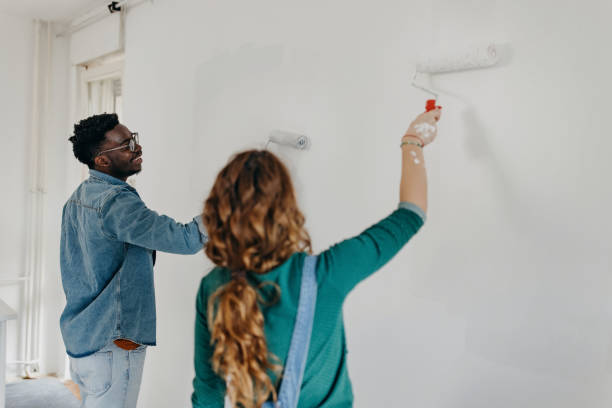 istock Young  couple painting walls 1372984875