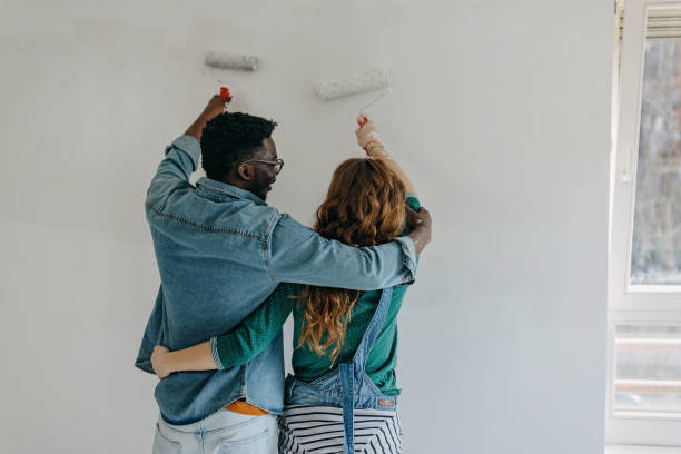 istock Young  couple painting walls 1372984876