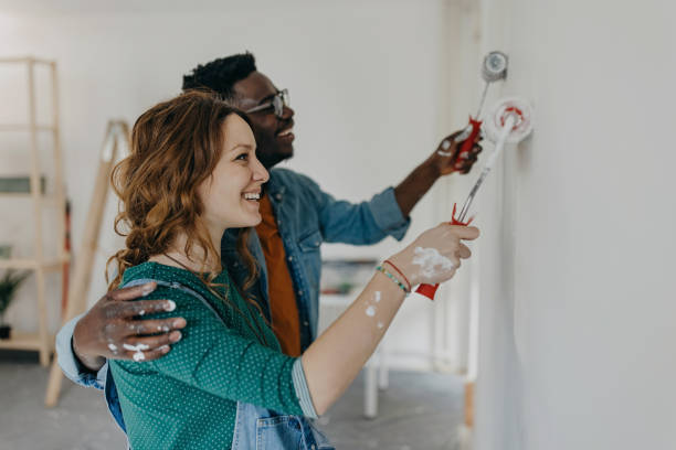 istock Young  couple painting walls 1372984880