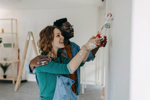 istock Young  couple painting walls 1372984887