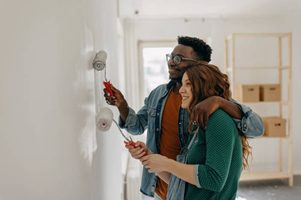 istock Young  couple painting walls 1372984907