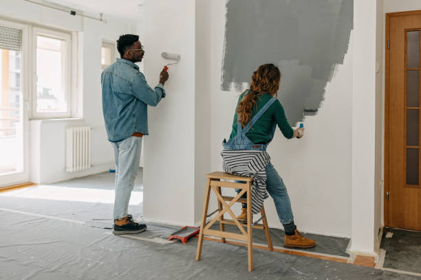 istock Young  couple painting walls 1372984910