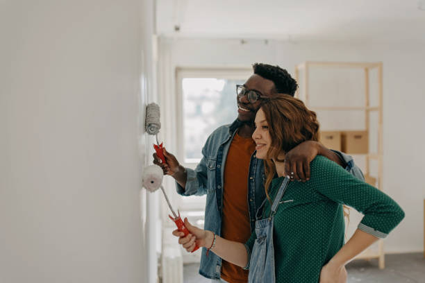 istock Young  couple painting walls 1372984913