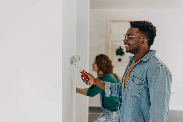 istock Young  couple painting walls 1372984927