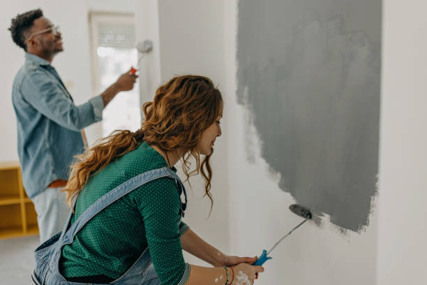 istock Young  couple painting walls 1372984929
