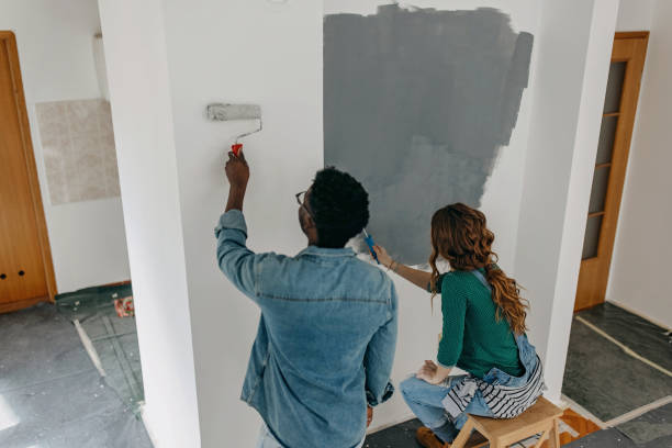 istock Young  couple painting walls 1372984932