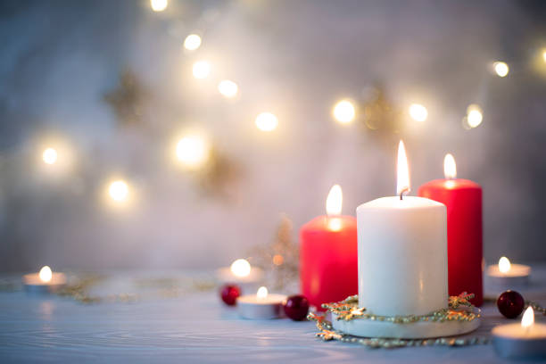 istock three burning candles and christmas garland on a blue background 1372985095