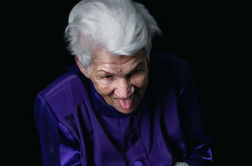 Senior woman, Grandma sticking her tongue out to make a silly face for the camera.