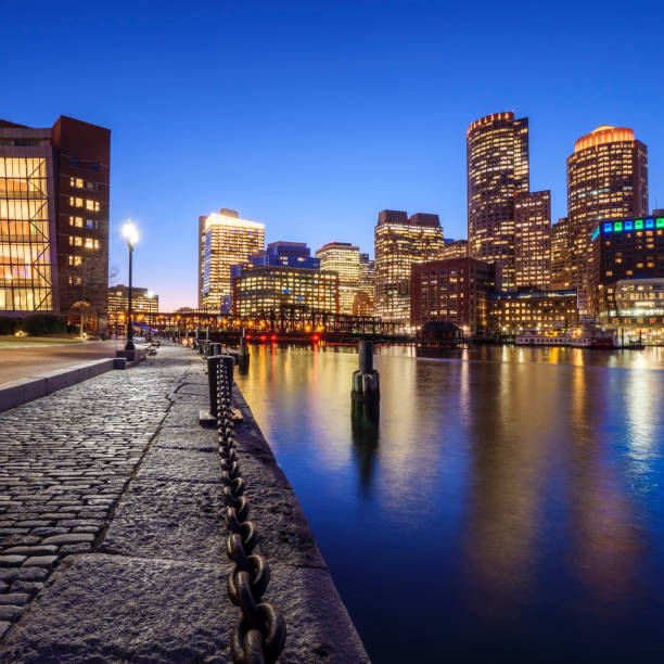 Boston View of Boston in Massachusetts, USA at Boston Harbor and Financial District showcasing its mix of contemporary and historic buildings. boston skyline night skyscraper stock pictures, royalty-free photos & images