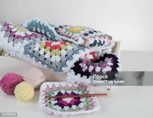 Colorful Granny Square Pattern With Crochet Hook And Woolen Balls In Wooden Box Stock Photo - Download Image Now