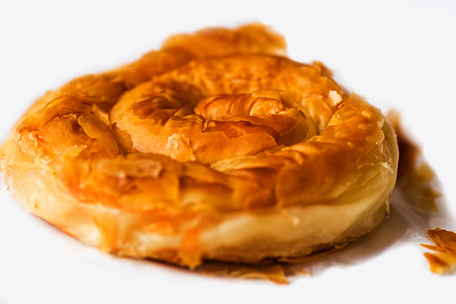 Tyropita strifti, greek spiral pastry from filo dough (puff pastry) stuffed with cheese, closeup.