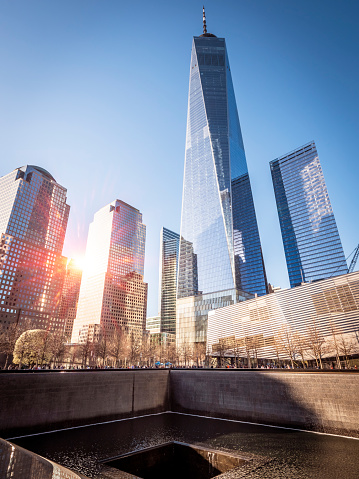 New York, USA - March 22, 2018: view of the iconic architecture of New York city in the USA at the World Trade Center rebuilt spot also called Ground Zero with the Crater left by one of the twin towers and the brand-new Liberty Tower.