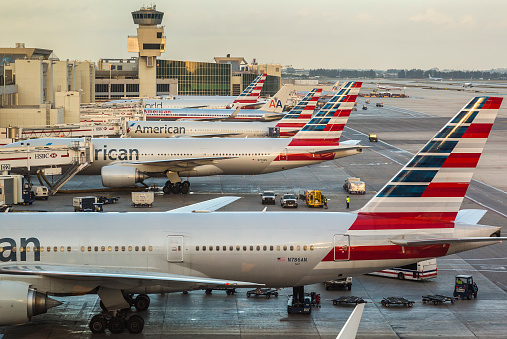 Miami, Florida, USA - June 25, 2018: view of some airplane tails through a window at the Miami Airport in the state of Florida in the USA on a sunny summer day.