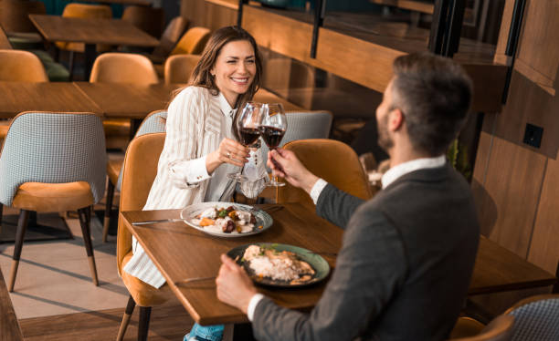 istock Elegant couple having lunch and toasting with wine in a restaurant. 1373000049