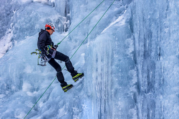 istock Ice climber rappelling from a frozen waterfall 1373001429